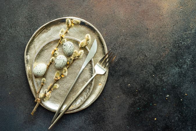 Easter table setting with eggs and pussy willow on neutral ceramic plates