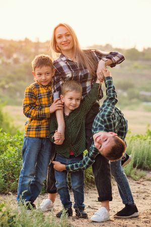 Happy mother and sons at sunset together