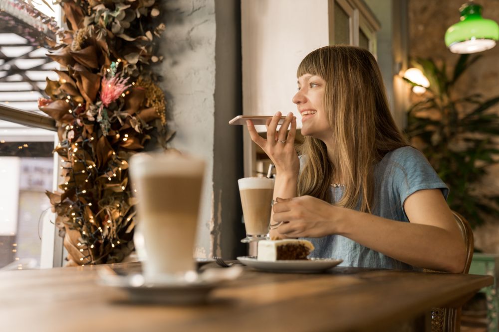 Cheerful woman talking on phone in cafe