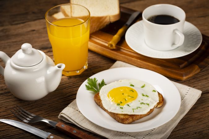 Breakfast with juice, coffee and toast with fried egg.