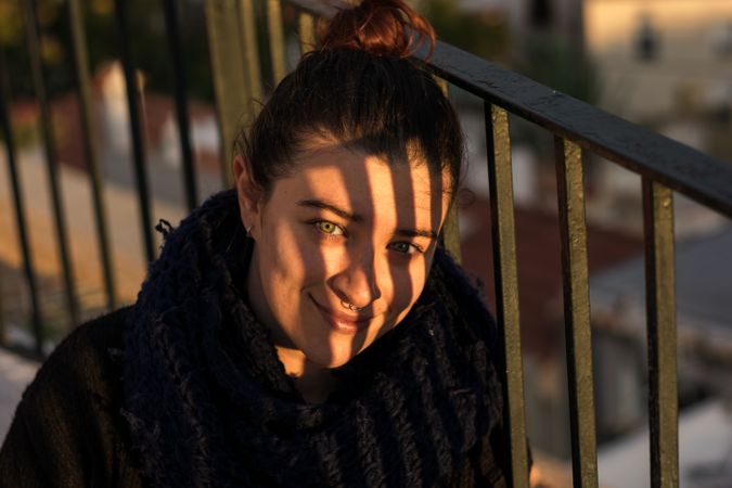 Pleased young woman with scarf on sunny day