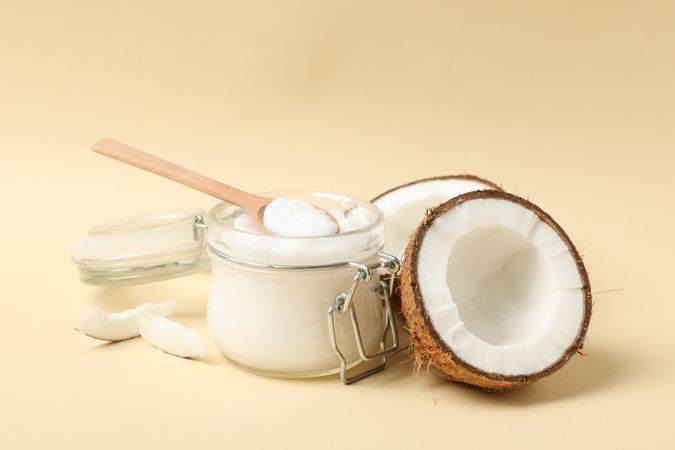 Coconut and cosmetic on beige background. Tropical fruit