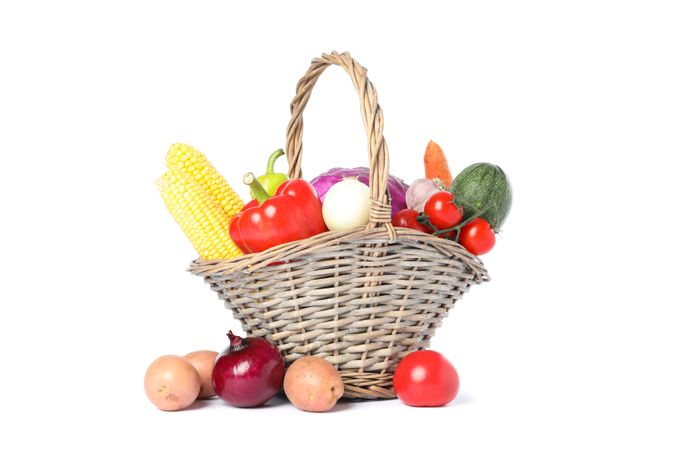 Wicker basket with vegetables isolated on blank background
