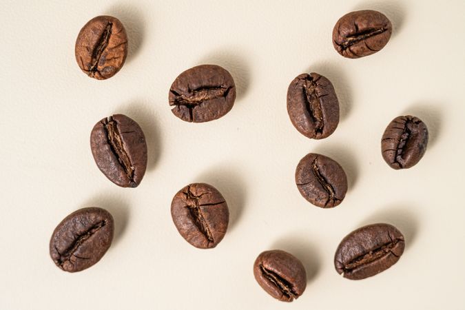 Flat lay of roasted coffee beans scattered on a surface.