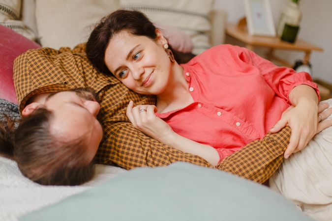 Man and woman cuddling and lying on bed