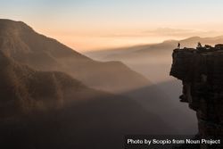 Man standing on cliff near mountains bDAAQ0