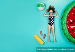 Top view of excited girl in swimwear lying on blue background 0gaOl4