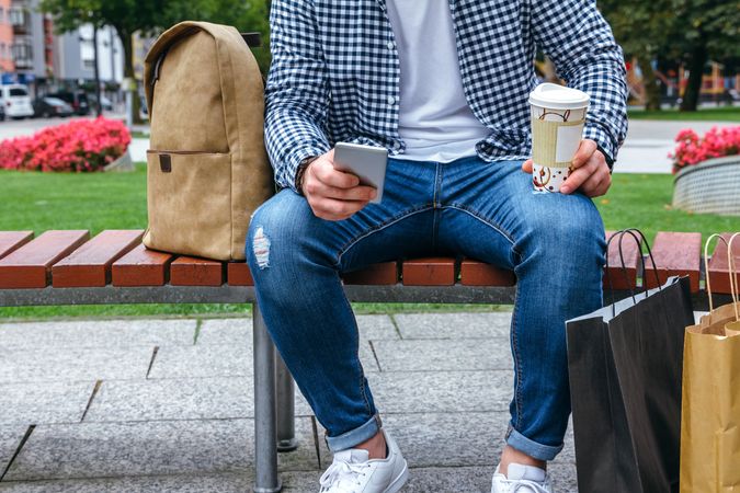 Man looking mobile sitting on a bench