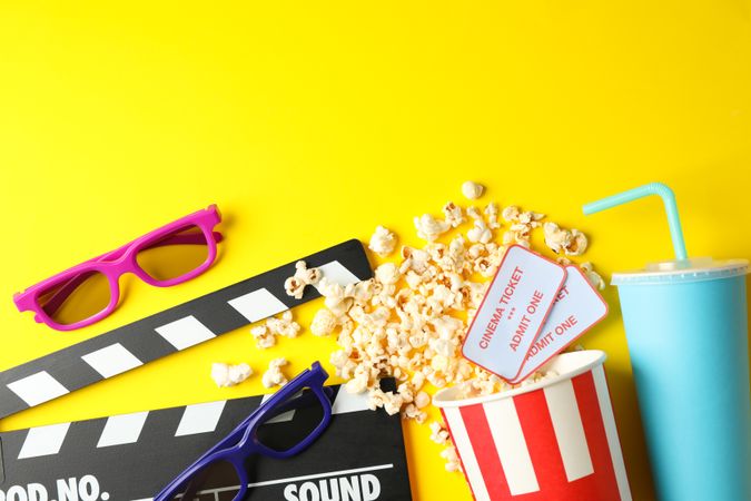 Flat lay composition with movie watching accessories on yellow background