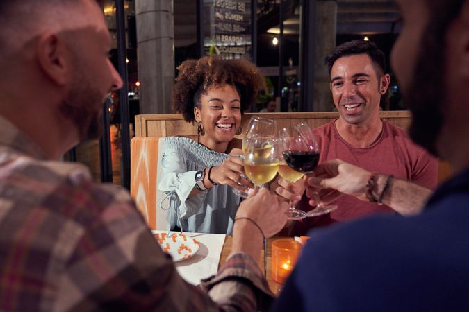 Happy friends clinking glasses of wine