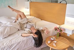Young woman relaxing on bed in morning