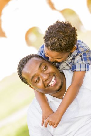 Black Father and Son Playing Piggyback in sunny Park