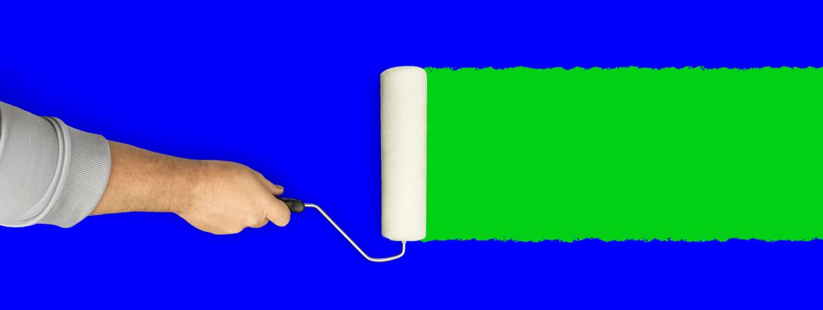Male Hand Rolling Paint Roller Over Blue and Green Screen Background.
