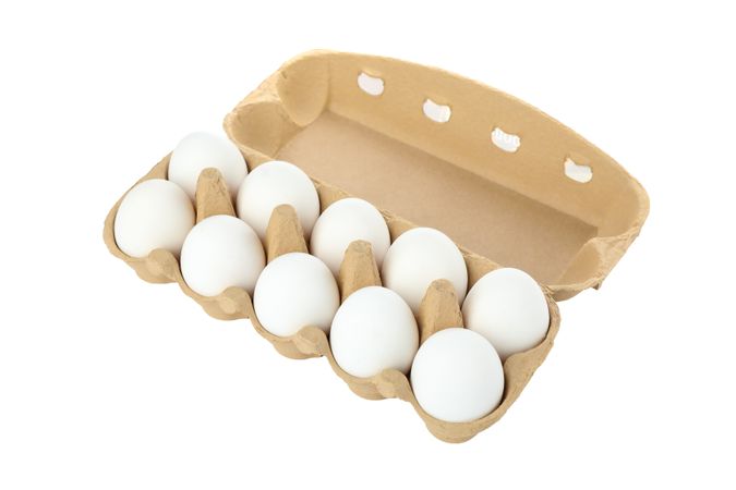 Few raw chicken eggs in carton box on blank background