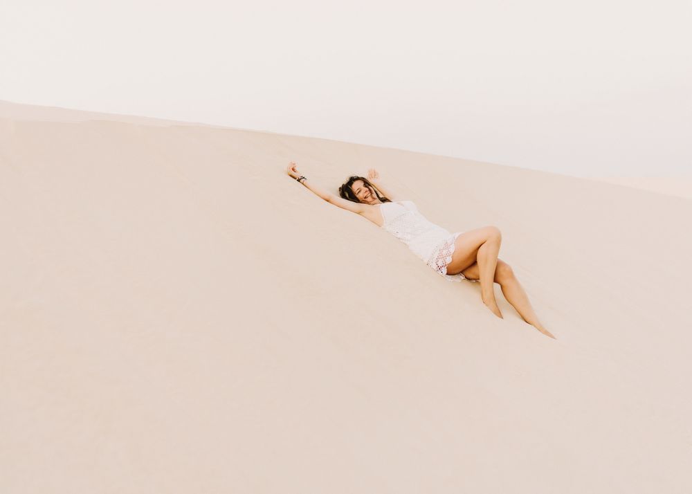 Woman lying on sand in desert