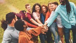 Friends joining hands in circle outdoors