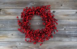 Red berry holiday wreath on old wood