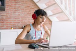 Woman in headphones working at laptop at home 4djNa0