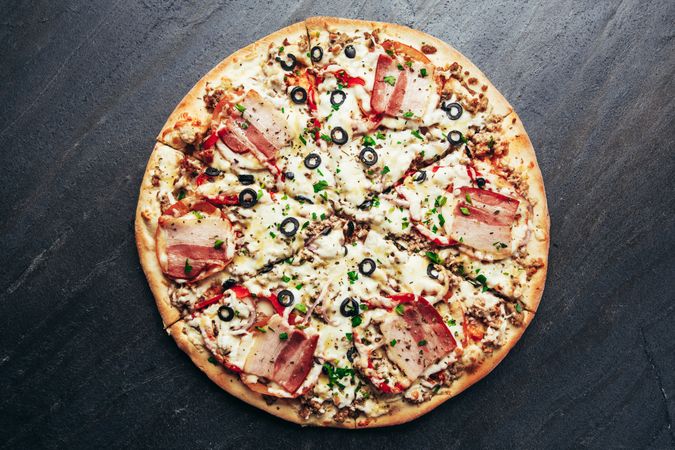 Ham pizza on stone table