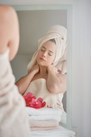 Woman in towel relaxing at mirror