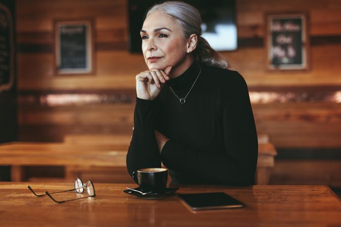 Thoughtful mature female at coffee shop