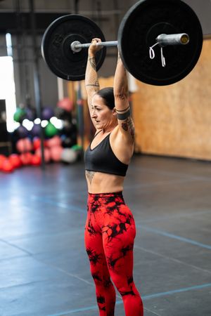 Sporty woman lifting weights alone in a gym