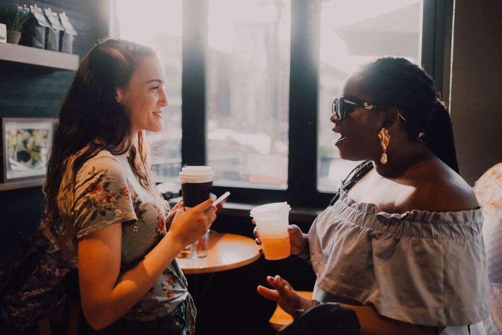 Multiethnic modern women relaxing at coffee shop