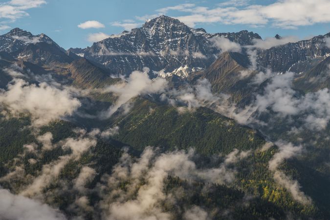 Picturesque view of top of mountains between clouds