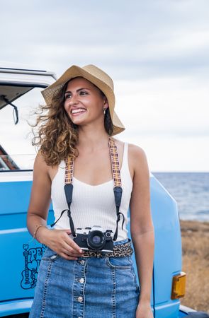 Touristic woman with photo camera on neck looking away