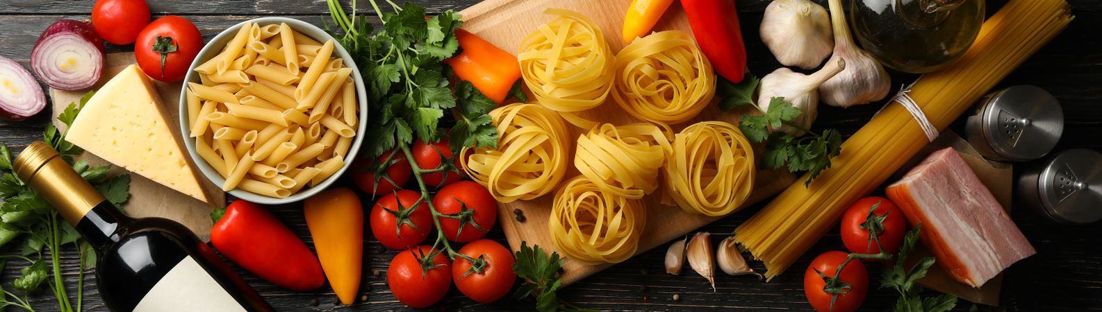Composition with pasta and ingredients for cooking on wooden background, top view
