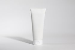 Mockup of plastic tube of cream on plain background