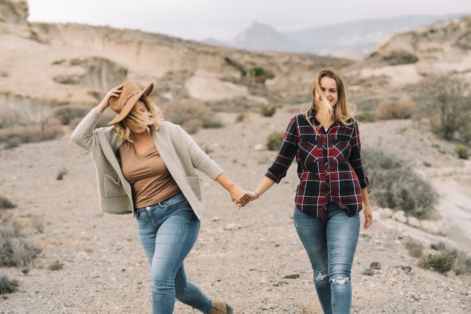 Blond women holding hands on nature