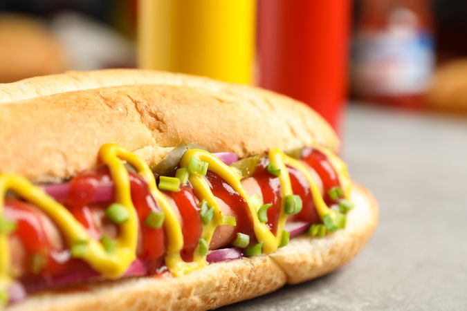 Tasty hot dog on gray table, close up
