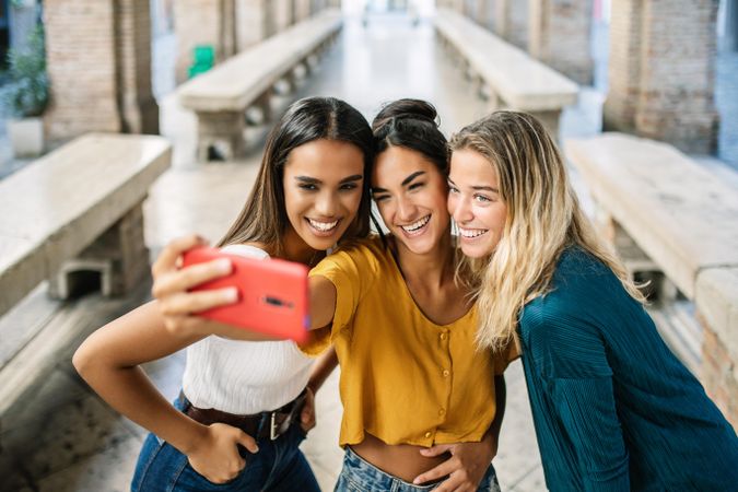 Three multi-ethnic women posing for selfie