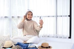 Young Asian Muslim Woman Taking Selfie in Hotel While Traveling