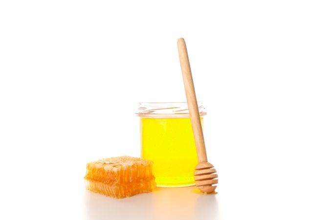 Glass jar, honeycomb and dipper isolated on blank background