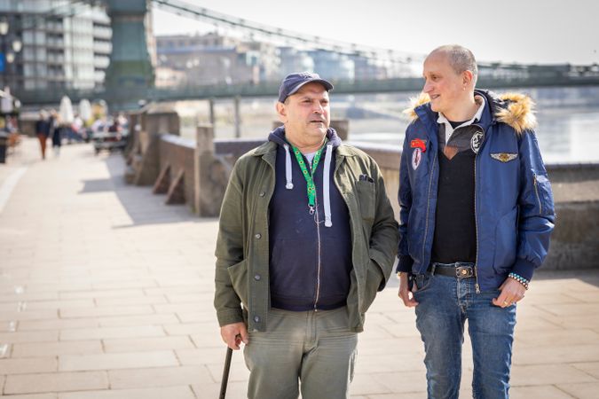 Two mature males walking along the Thames path in London