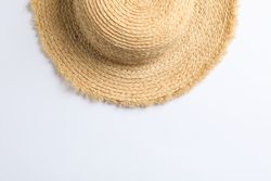 Pretty straw hat on blank background. Space for text, top view