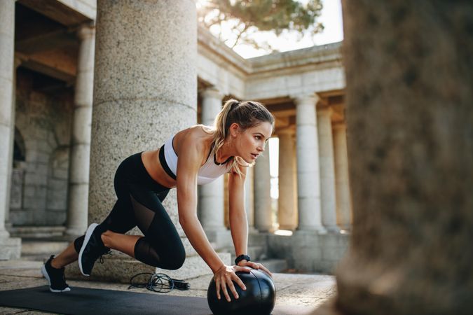 Fitness woman doing push ups using a medicine ball