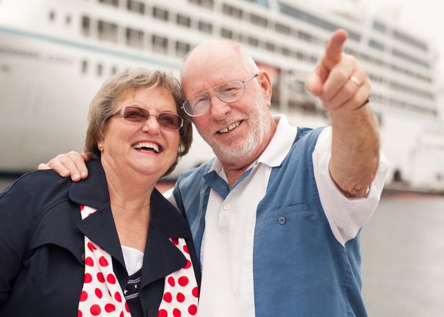 Older Couple On Shore in Front of Cruise Ship