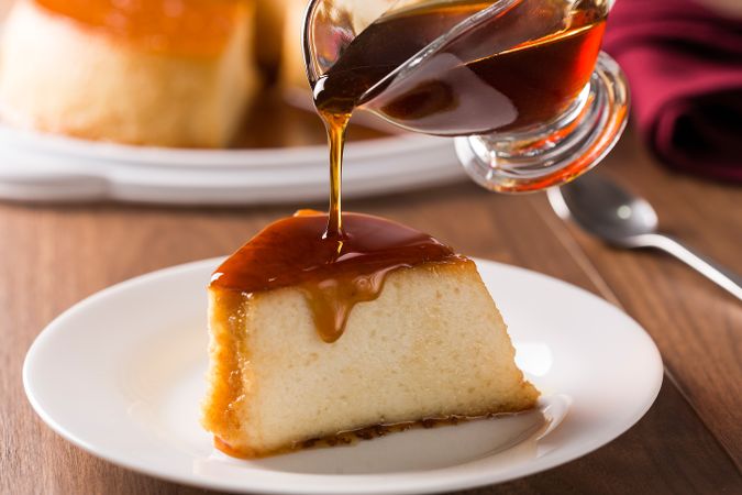 Caramel being poured over slice of panna cotta or flan