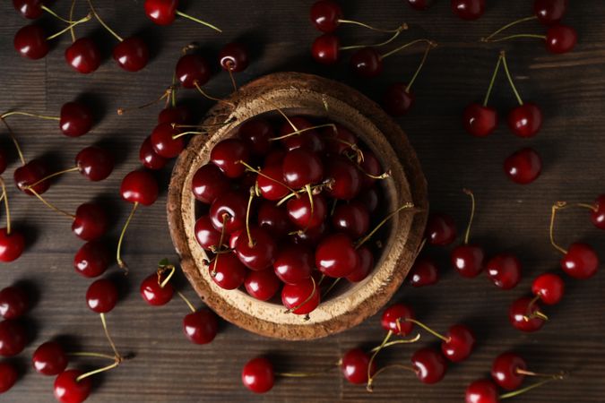 Ripe cherry fruits in a bowl on a wooden background
