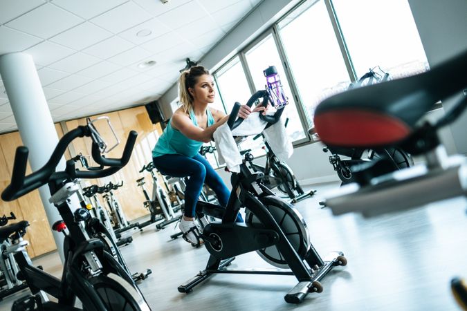 Woman with towel and water on exercise machine