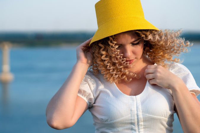 Portrait happy woman in yellow hat in windy outdoors