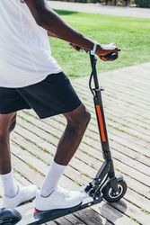 Black man riding on electric scooter in park