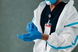 Black woman removing her protective gloves