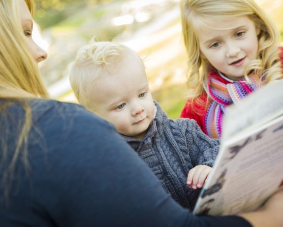 Mother Reading a Book to Her Two Adorable Blonde Children.