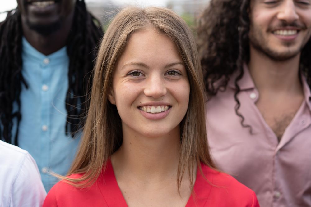 Woman standing and smiling in the middle of multiethnic group