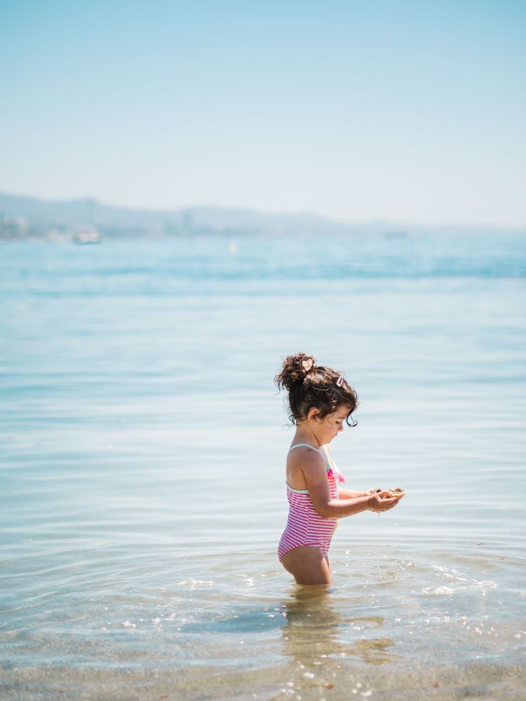 Cute girl playing in water of seaside