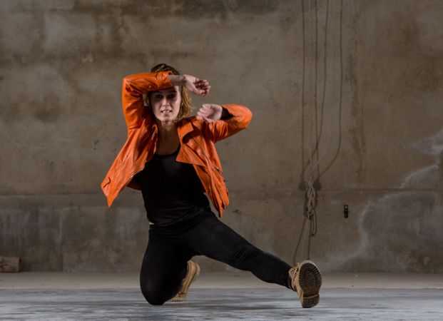 Young woman jumping in grey room